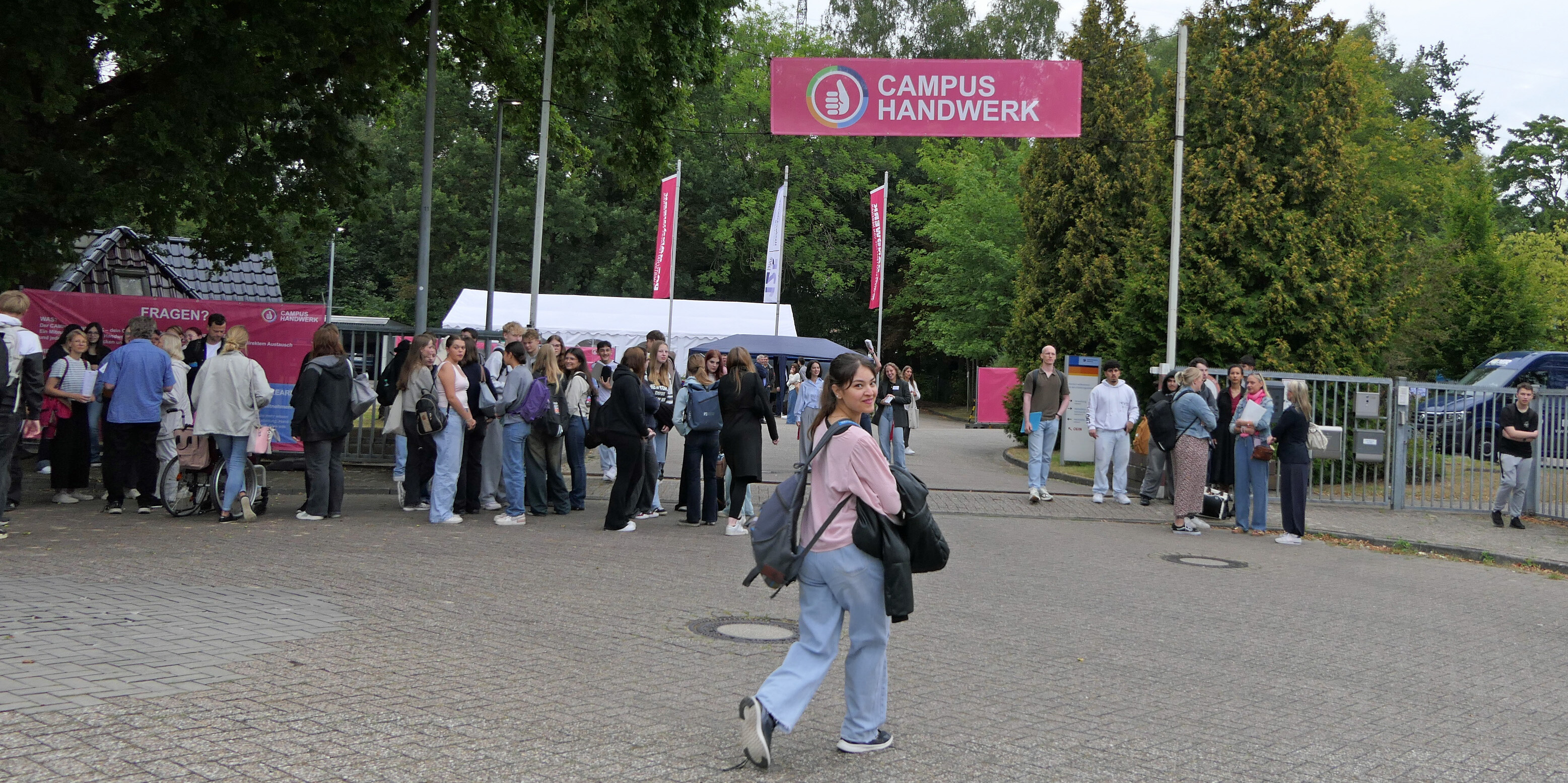 KI generiert: Das Bild zeigt eine Gruppe von Menschen, die sich vor einem Eingang mit einem Schild "Campus Handwerk" versammelt haben.