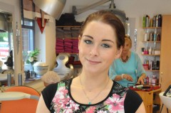 Auszubildende zur Friseurin steht in Friseursalon.
