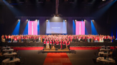 KI generiert: Das Bild zeigt eine große Gruppe von Menschen auf einer Bühne, die offenbar an einer Veranstaltung namens "Meisterfeier 2026" teilnimmt.