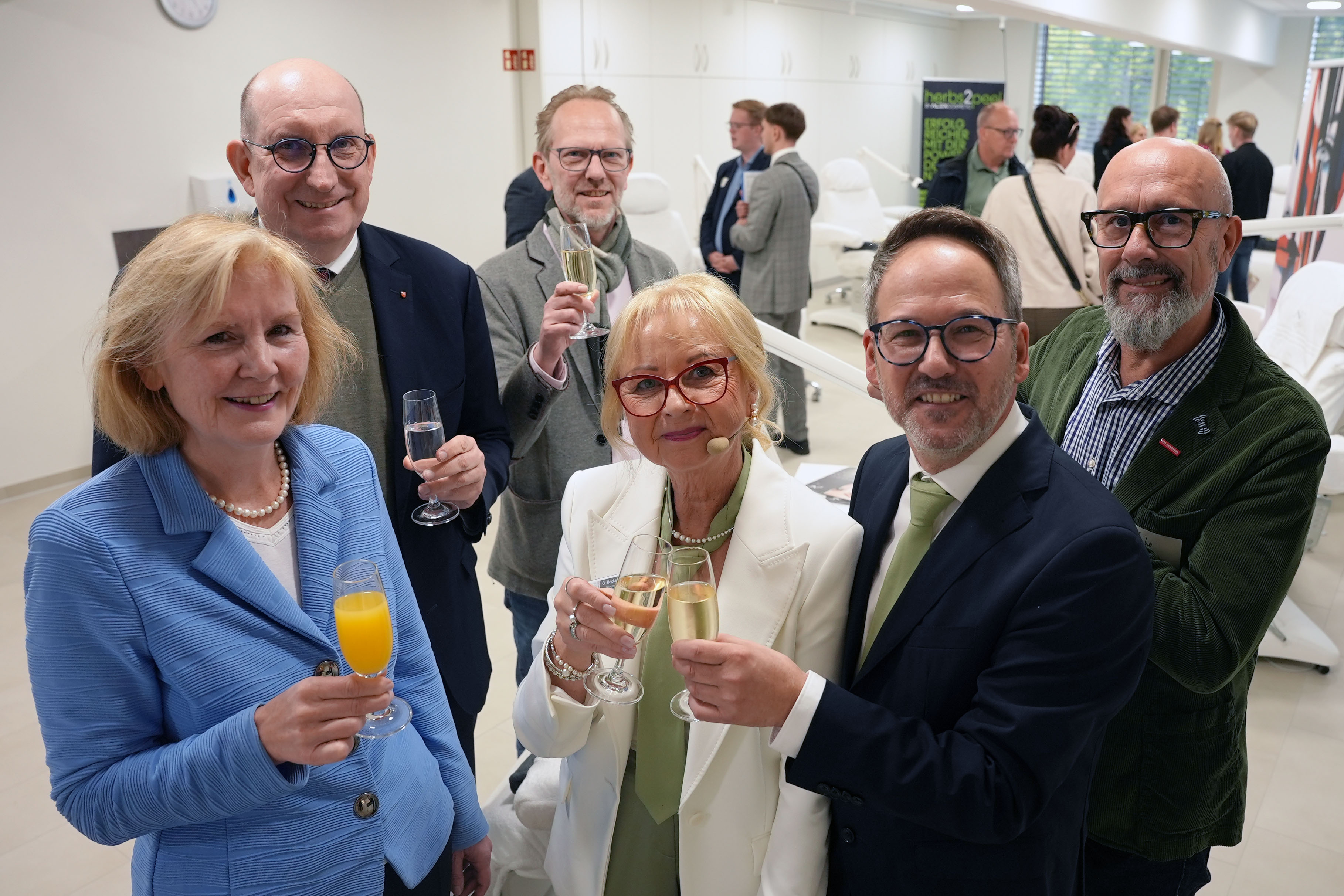 KI generiert: Das Bild zeigt eine Gruppe von Menschen, die auf einer Messe oder Ausstellung stehen und verschiedene Getränke in ihren Händen halten, während sie sich unterhalten und lächeln.